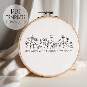 Può includere: Un telaio da ricamo con tessuto bianco con un disegno floreale nero e il testo "Old ways won't open new doors". Le parole "PDF TEMPLATE DOWNLOAD" sono in un cerchio in alto a sinistra.