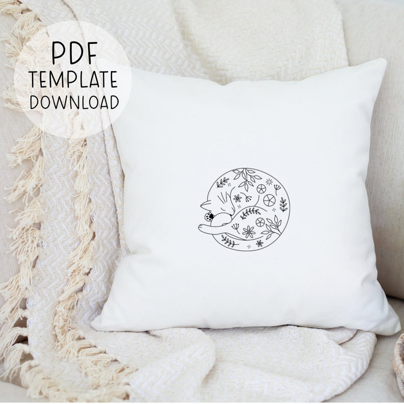 May include: A white pillow with a black line drawing of a cat curled up inside a circle of flowers and leaves. The text "PDF TEMPLATE DOWNLOAD" is in the upper left corner of the image.