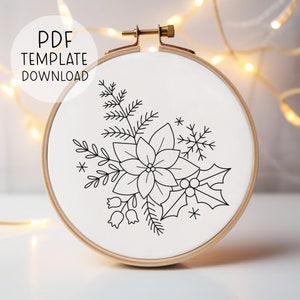 May include: A black and white line drawing of a poinsettia, holly, and pine branches on a white background. The design is in a round embroidery hoop.