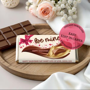 May include: A chocolate bar with the words "be mine" and "Happy Valentines" printed on the wrapper. A pink bow and hearts decorate the wrapper. A second chocolate bar is visible. The image also includes text that says "Instant Download" and "Easy Edit in Canva".
