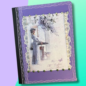 Può includere: Un diario decorativo viola, ornato con bordi in pizzo e piccole perline verdi. Il diario presenta un'immagine in stile vintage di una donna in un lungo abito, con dettagli floreali e testo. Il dorso del diario è nero.