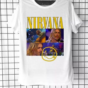 Peut inclure: T-shirt blanc avec un graphisme jaune "NIRVANA" et un collage d'images de Kurt Cobain. Le graphisme comprend également un smiley jaune avec deux X pour les yeux.
