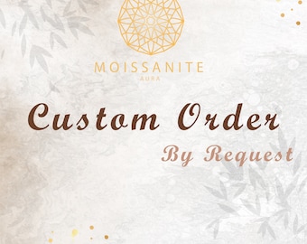May include: A graphic with a geometric design in gold on a white background. The text "Moissanite Aura" is below the design. The text "Custom Order By Request" is below the text "Moissanite Aura".