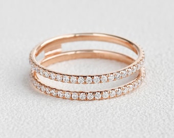 May include: A rose gold ring with two bands of pave set diamonds.