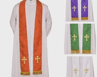 May include: An orange clergy stole with a gold cross and gold fringe. Additional stoles in purple, green, and white are also shown, each with a gold cross and gold fringe. The stoles are worn over a white robe.