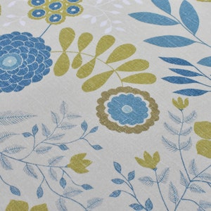 Könnte beinhalten: Ein weißer Stoff mit einem blauen und grünen Blumenmuster. Das Muster zeigt stilisierte Blumen, Blätter und Zweige.