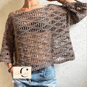 May include: A brown, open-weave crochet top with three-quarter sleeves. The top has a boat neck and a loose, relaxed fit. The image includes the text "C" and "@clacrochet".