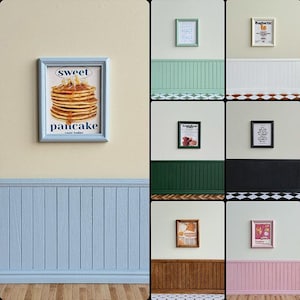 May include: A collection of miniature framed artworks, including a pancake stack poster and other illustrations. The walls are painted in pastel shades of blue, green, and pink, with decorative paneling and flooring. Each frame has a different design.