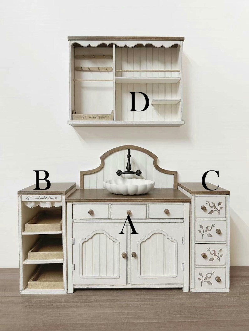 Pu&ograve; includere: Un set da cucina in miniatura bianco e marrone con lavandino, armadietti e una mensola a muro. Il set include un lavandino con un rubinetto nero, cassetti e un armadietto con ante. La mensola a muro ha ganci e ripiani.