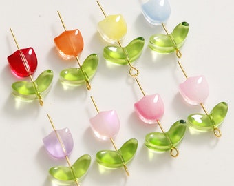 Könnte beinhalten: Sortiment aus acht bunten Glas-Tulpenblumenperlen mit goldenen Drahtstielen und grünen Glasblättern. Die Perlen sind in den Farben Rot, Orange, Gelb, Hellblau, Rosa und Lila.