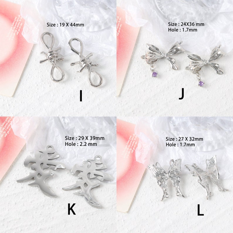 May include: Four pairs of silver metal charms. The first pair is a barbed wire design, the second pair is a bow with a purple rhinestone, the third pair is a Chinese character, and the fourth pair is a butterfly.