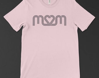 May include: A pink t-shirt with a black graphic design of the word "MOM" with a heart in the middle of the "O".