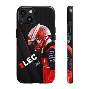 May include: A black phone case with a red and black diagonal stripe. The case features a photo of a race car driver wearing a red helmet and red racing suit. The driver's name, "LEC 16", is printed in white on the case.