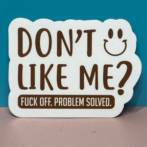 May include: White sticker with brown text that reads "Don't like me? Fuck off. Problem solved." A smiley face is next to the word "Don't".