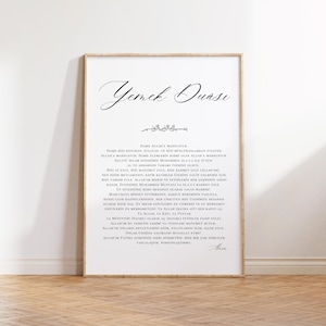 May include: A framed print with a wooden frame, featuring elegant calligraphy in black script on a white background. The text appears to be in a foreign language, possibly Arabic or Turkish, and is centered on the print.