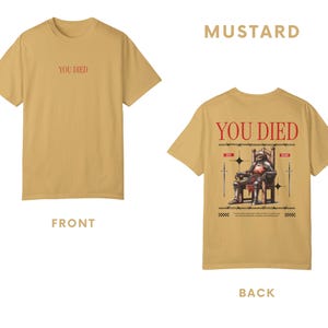 May include: A mustard yellow t-shirt with the text "You Died" printed on the front and a graphic of a knight sitting on a throne with the text "You Died" printed on the back.