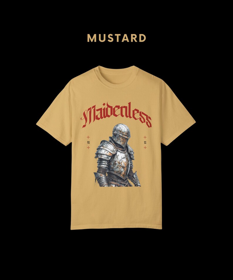 May include: A mustard yellow t-shirt with a graphic of a knight in armor. The text "Maidenless" is printed in red above the knight.