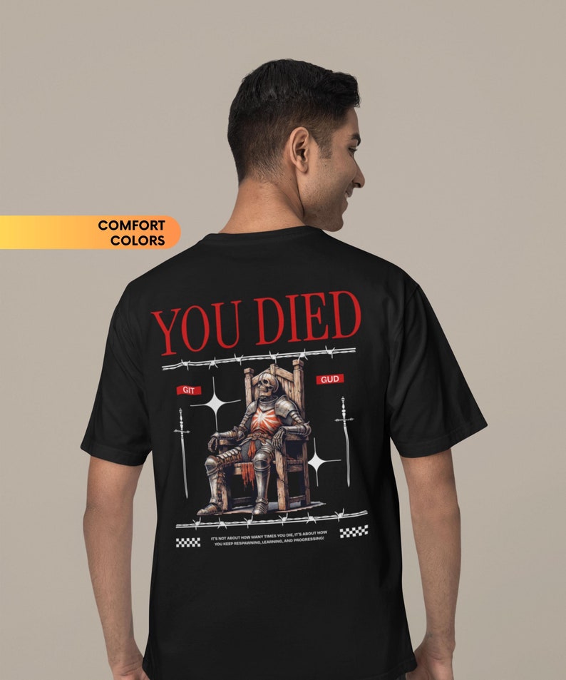 May include: Black t-shirt with a graphic of a skeleton knight sitting on a throne with the words "YOU DIED" above it. The text "GIT GUD" is below the image. The text "IT'S NOT ABOUT HOW MANY TIMES YOU DIE. IT'S ABOUT HOW YOU KEEP RESPAWNING, LEARNING, AND PROGRESSING." is below the text.