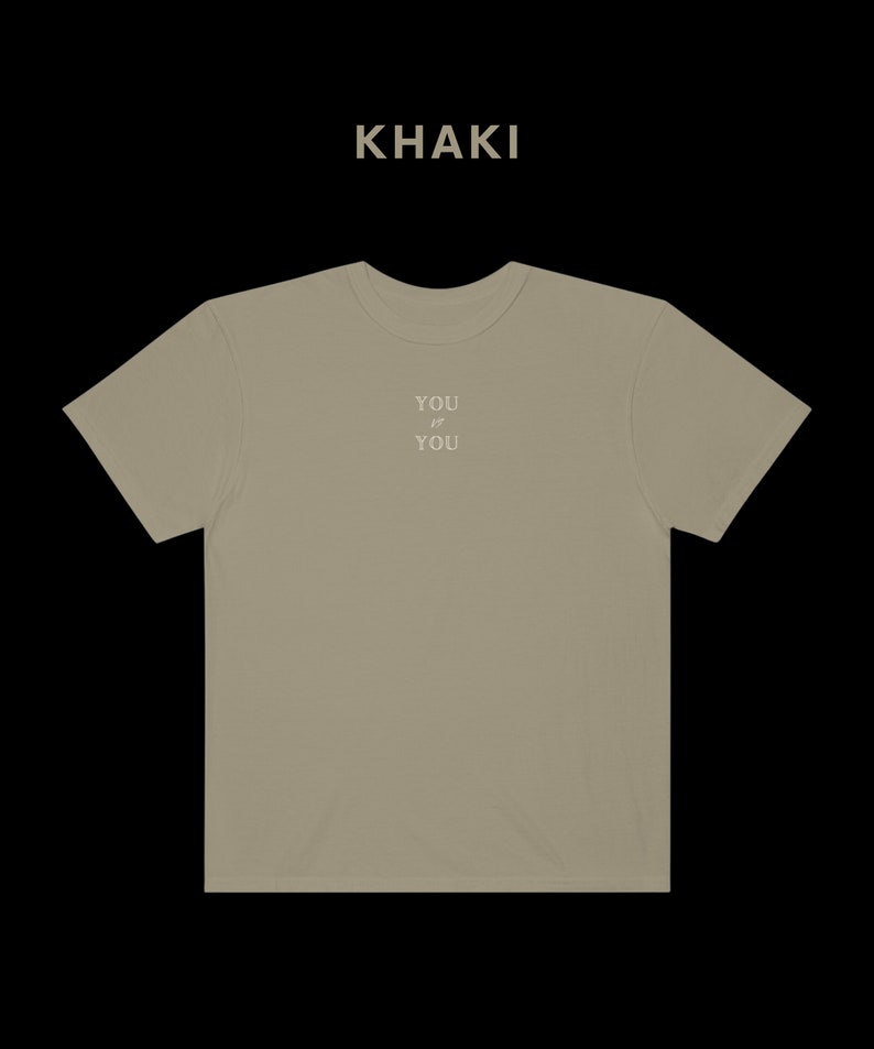 Pu&ograve; includere: T-shirt color kaki con la scritta "YOU  IS  YOU" stampata sul davanti.