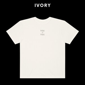 Pu&ograve; includere: Una maglietta bianca con la scritta "YOU IS YOU" stampata sul davanti.