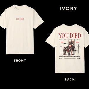 May include: Ivory t-shirt with the text "YOU DIED" on the front and a graphic of a knight sitting on a throne with the same text on the back.