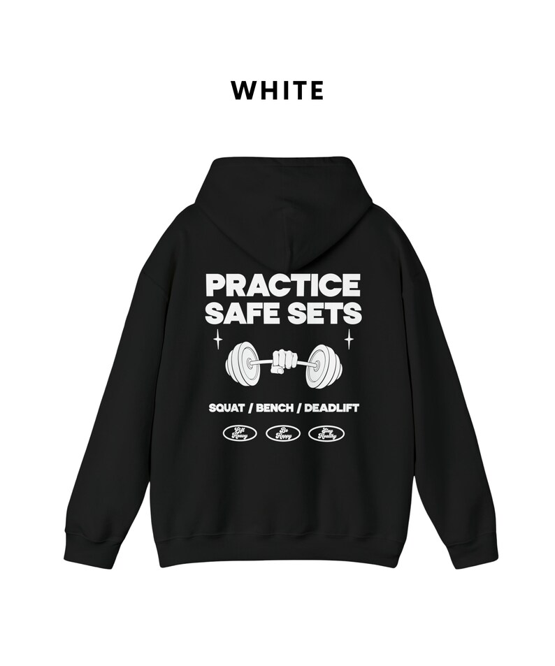 K&ouml;nnte beinhalten: Schwarzer Kapuzenpullover mit dem Text "PRACTICE SAFE SETS" und einer Grafik einer Langhantel, die von einer Hand gehalten wird. Der Text "SQUAT / BENCH / DEADLIFT" befindet sich unter der Grafik. Drei kleine Kreise mit dem Text "Safe Heavy" befinden sich unter dem Text.