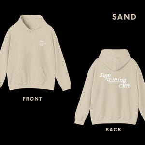 May include: A sand-coloured hoodie with the text "5am Lifting Club" in white on the back and a smaller version of the text on the front.