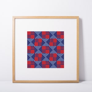 May include: A framed artwork with a geometric pattern in red, blue, and light blue. The design features repeating shapes, creating a symmetrical composition. The frame is made of light-coloured wood. The artwork is displayed on a white background.