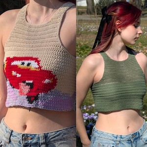 Pode incluir: Tops curtos de crochê em várias cores. Um top apresenta um design de carro de desenho animado vermelho. Outros tops são de cores sólidas, incluindo verde e lavanda. Os tops são sem mangas com gola alta.