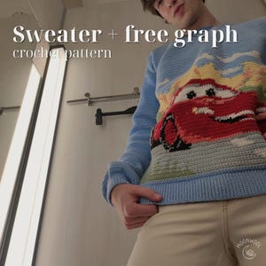 May include: A light blue long-sleeve crochet sweater featuring a large red car graphic on the front. The text "Sweater + free graph crochet pattern" is printed in white at the top left. The sweater has a ribbed hem and cuffs.