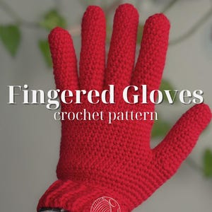 Può includere: Un guanto rosso brillante, lavorato all'uncinetto con dita individuali. Il testo "Fingered Gloves crochet pattern" è visualizzato in bianco. Il guanto è mostrato su uno sfondo sfocato. Il guanto è un articolo fatto a mano.