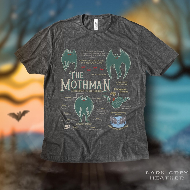 May include: Dark grey heather t-shirt with a graphic of the Mothman, a cryptid from Point Pleasant, West Virginia. The graphic includes the creature's name, scientific name, and a diagram of its physical characteristics. The text "The Mothman is a chilling and mysterious winged creature, sightings of which are in the city of Point Pleasant, West Virginia."
