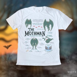 May include: White t-shirt with a green and black illustration of the Mothman, a cryptid from Point Pleasant, West Virginia. The illustration includes the creature's physical characteristics and the text "The Mothman, The Silent Flyer, Strigomantis Nocturnus, A Harbinger of Disaster, Mothman's Origins".