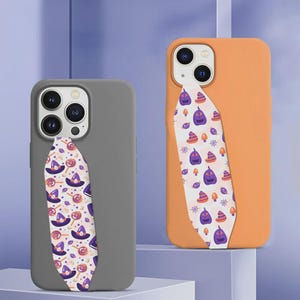 Op de afbeelding: Twee smartphonehoesjes, één matgrijs en één mat oranje, elk met een verticale band aan de achterkant. De band van het grijze hoesje toont een patroon van paarse heksenhoeden en oranje lolly's, terwijl de band van het oranje hoesje paarse pompoenen en oranje paddenstoelen bevat.