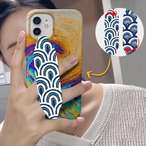 May include: A phone case with a colorful abstract design and a blue and white patterned phone grip. The grip can be rotated to be used as a kickstand.