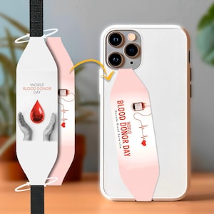 May include: A white phone case with a pink strap that says "World Blood Donor Day Donate Blood Save Life" in white text. The strap has a red blood drop and a heartbeat graphic.