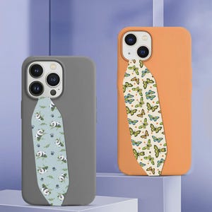 Puede incluir: Una funda de teléfono gris con una franja vertical azul claro con estampado de pandas y hojas, y una funda naranja con una franja vertical color crema con un patrón repetitivo de mariposas amarillas y azules en ambos dispositivos.