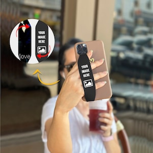 May include: A black phone grip with the text "YOUR IMAGE HERE" and a picture icon. The grip is attached to a brown phone case.
