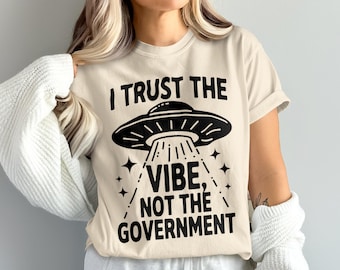 Camiseta "Confío en la vibra, no en el gobierno" con temática de ovnis, divertida camiseta de conspiración alienígena, sátira política humorística, ropa galáctica de ciencia ficción.