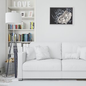 Pode incluir: Um sof&aacute; branco com duas almofadas fica em frente a uma estante branca com a palavra "LOVE" na prateleira superior. Uma pintura abstrata em preto e branco est&aacute; pendurada na parede acima do sof&aacute;.