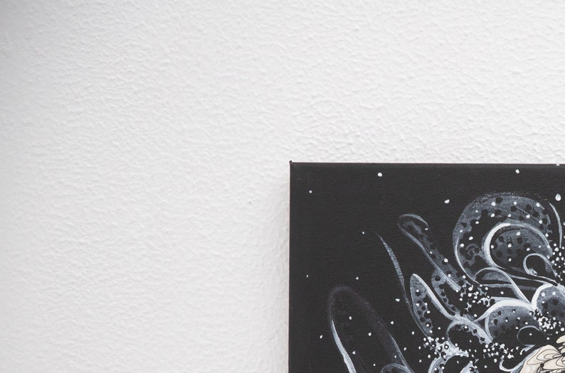 Pode incluir: Uma pintura em tela preta com desenhos abstratos brancos. O desenho apresenta formas e pontos em espiral.
