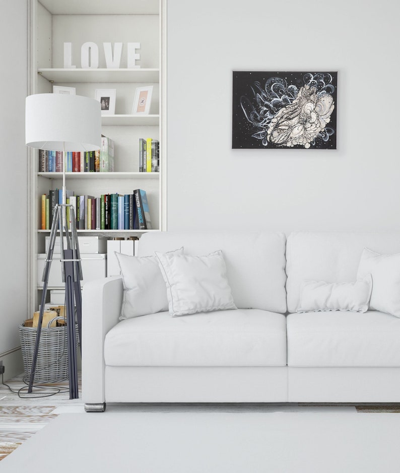 Pode incluir: Um sof&aacute; branco com duas almofadas fica em frente a uma estante branca com a palavra "LOVE" na prateleira superior. Uma pintura abstrata em preto e branco est&aacute; pendurada na parede acima do sof&aacute;.