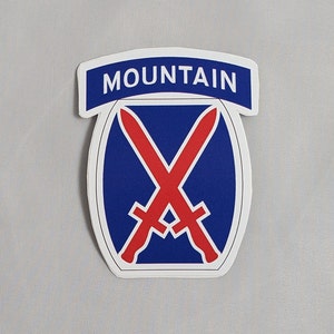 May include: A blue and white sticker with the words "MOUNTAIN" in white letters on a blue banner. The sticker features a blue oval with two red crossed swords.