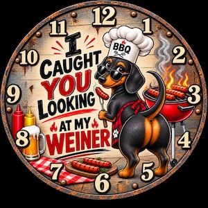 May include: A round wall clock with a wood-look background featuring a black and tan dachshund wearing a chef hat and sunglasses, standing by a red grill. The text reads I CAUGHT YOU LOOKING AT MY WEINER, with illustrations of sausages, beer, and flames.
