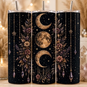 Puede incluir: Un vaso cilíndrico con fondo negro que presenta un diseño de fases lunares en dorado, incluyendo una luna llena y dos crecientes. La superficie está decorada con patrones florales intrincados, dijes de cristal colgantes y estrellas.