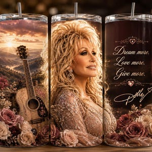 May include: A cylindrical tumbler with a metal straw featuring a portrait of Dolly Parton, a mountain landscape at sunset, an acoustic guitar, and roses. The text reads: Dream more. Love more. Give more. Dolly, with decorative heart accents.