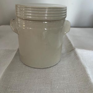 May include: A set of three ceramic mugs with a speckled, matte finish. The mugs are in shades of cream, light gray, and dark gray. Each mug has a simple, minimalist design, perfect for coffee or tea.