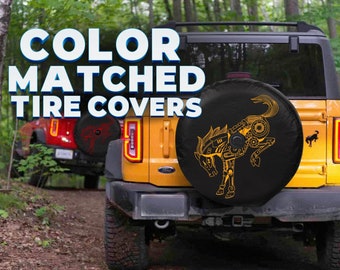 May include: Yellow SUV with a black spare tire cover featuring a gold mechanical horse design. The text "COLOR MATCHED TIRE COVERS" is displayed in white and blue. Another red SUV is visible in the background.