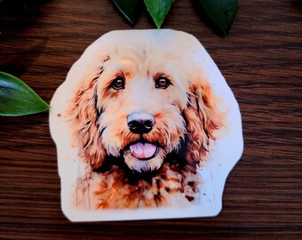 Könnte beinhalten: Eine Aquarell-Illustration eines Goldendoodles mit braunen Augen und einer rosa Zunge, die herausstreckt. Der Hund schaut direkt auf den Betrachter.