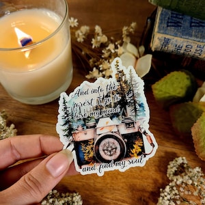 May include: A sticker with a watercolor illustration of a camera in a forest with the text "And into the forest I go to lose my mind and find my soul."